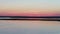 Nature of Russia: bird island at sunset, flight of seagulls against a pink sky, aerial view