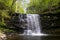 Nature\\\'s Elegance: A Medium-Sized Pennsylvania Waterfall Trailing Over Rocky Terrain