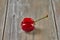 Nature's Oddity: ugly, irregularly shaped cherry stands out against a rustic wooden backdrop