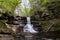 Nature\\\'s Symphony: A Northeast Waterfall Cascading Over Rocks Amidst Lush Green Foliage