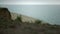 Nature scene sandy coastline cloudy day. Karate man training near ocean waves.