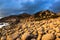 Nature Seascape with Eggshaped Rocks on A Wild Beach and Rocky Mountains at Dramatic Sunrise