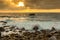 Nature Seascape with Eggshaped Rocks on A Wild Beach, Waves and Sun Rays at Dramatic Sunrise