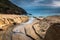 Nature Seascape with A Stream Across Sandy Beach towards Ocean