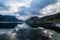 Nature summer landscape in Norway with mountains, fjord and cloudy sky