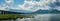 Natures spectacle: panoramic view of a serene dam, majestic mountains, and sky