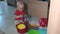 Naughty child playing with bowls on kitchen floor