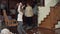 Naughty children throwing things around the house of grandparents. Grandmother and grandfather standing on the