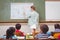 Naughty pupil about to throw paper airplane in class