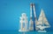 nautical concept with white decorative lighthouse lantern, wooden oars and boat over blue background.