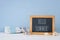 nautical concept with wooden decorative boat oars, beach chair, sea shells and blackboard over blue background.