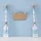 nautical concept with wooden decorative boat oars and empty note for copy space hanging on a string over blue background.