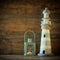 nautical lifestyle concept. old vintage lighthouse and lantern on wooden table. vintage filtered image