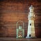 Nautical lifestyle concept. old vintage lighthouse and lantern on wooden table. vintage filtered image