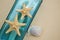 Nautical Theme Backdrop, Decorative Bottle with Shells, Starfish on Neutral Ivory Background. Place for text. Selective focus.