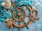 Nautical Theme with Wooden Ship\\\'s Wheel, Aquatic Starfish, Seashells, and Marine Knot on Blue Textured Background