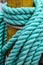 Nautical turquoise rope wrapped around wood post on sailing ship