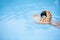 Nautilus seashell in child hands with crystal blue water