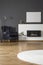 Navy blue armchair between lamp and silver table in apartment in