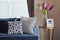 Navy blue modern classic sofa and retro, gray and blue pillows with a lovely orchid vase