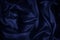 Navy blue silk satin. Beautiful wavy folds. Dark elegant background with space for design.