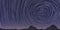 Navy blue stargaze background. Night sky spinning stars trail texture. Stargazing mountains silhouette backdrop. Night stars