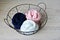 Navy, pale pink and white merino wool in round wire basket