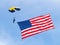 Navy parachuter with American flag blue cloudy sky background