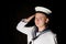 Navy seaman saluting on black