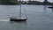 A navy and white yacht sails the gray-green-blue waters of NYC\\\'s East River.