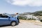 Naxos, Greece - May 2018: woman driving convertible blue rental car without roof on mountain road next to Filoti village