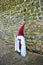 Nazarene before the stone wall, Holy Week in Baeza, Jaen province, Andalusia, Spain