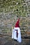 Nazarene before the stone wall, Holy Week in Baeza, Jaen province, Andalusia, Spain