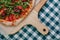 Neapolitan spicy pizza with ham, cheese, arugula, basil, tomatoes, pepperoni pepper sprayed with cheese on a wooden board on a