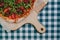 Neapolitan spicy pizza with ham, cheese, arugula, basil, tomatoes, pepperoni pepper sprayed with cheese on a wooden board on a