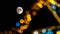 Near full moon in shot with bokeh Christmas display lights out of focus