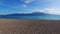 Near-horizontal shot by drone flying low above sandy beach and the waters of the Gulf of Corinth, Nafpaktos Lepantio, Greece