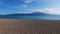 Near-horizontal shot by drone flying low over sandy beach and the waters of the Gulf of Corinth, Nafpaktos Lepanto, Greece