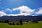 Near the mountain is a large estate with houses and greenhouses against the background of a bright sky