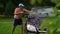 Near nude fat guy in shorts washing foamy soapy car with brush outdoor