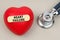 Near the stethoscope lies a heart on which a sticker is pasted with the inscription - HEART FAILURE