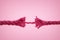 Nearly broken rope on pink background - Concept of violence against women