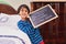 Nearly done with the chores. Portrait of a young boy holding a chalkboard with chores written on.