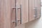 Neat aluminum door handles for kitchen furniture. Wooden door of the kitchen cabinet