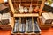 Neat arrangement of cutlery, napkin and hanging bottles of condiments at a cafe