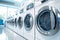 A neat row of sleek clean washing machines in a modern, well-lit laundromat. The concept of streamlined laundry, energy-efficient