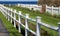 Neat sections of white picket fences with flowers and shrubs at the beach