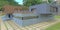 A neat veranda of a pretty cottage nestled in the dense foliage of a tropical park. Wall cladding with concrete, gray and brown