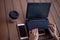 Neat young female hands with a modest manicure, with large wrist watches, work at a laptop, standing on a wooden table.