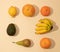 Neatly arranged fresh fruit on sandy colored background. Minimal flat lay